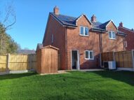 A new build with a green grass and a shed