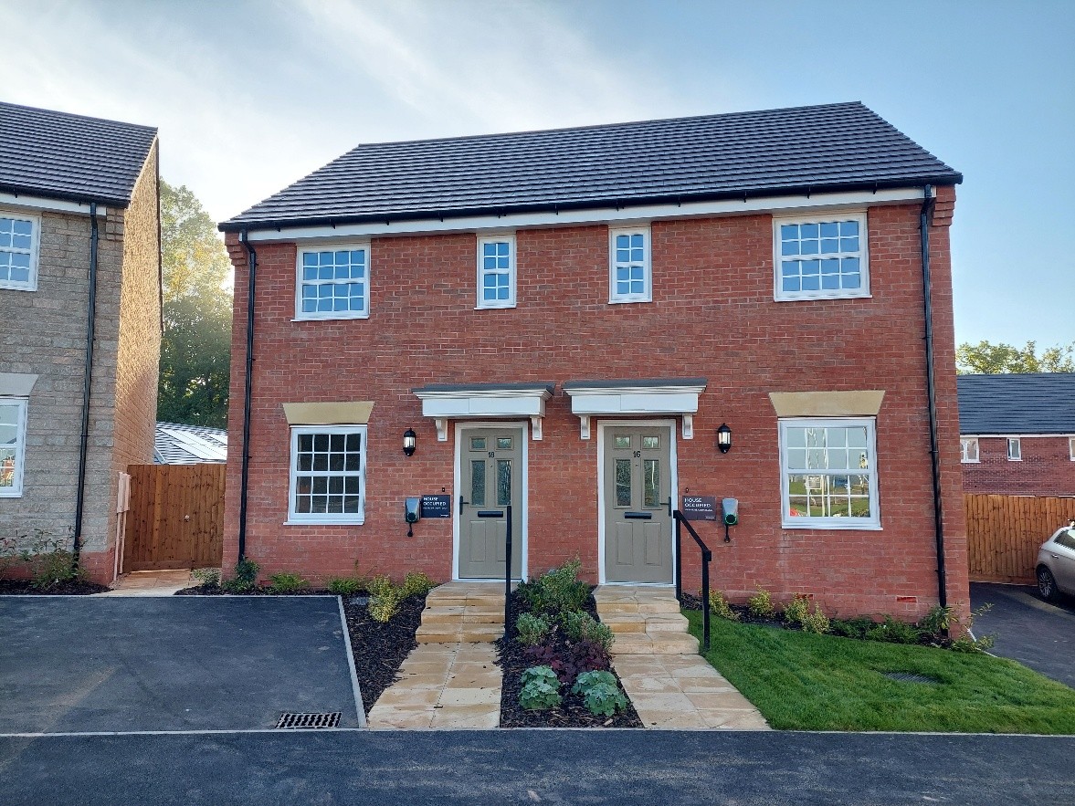 Redbrick semi detached new homes, with white window panes and brown doors